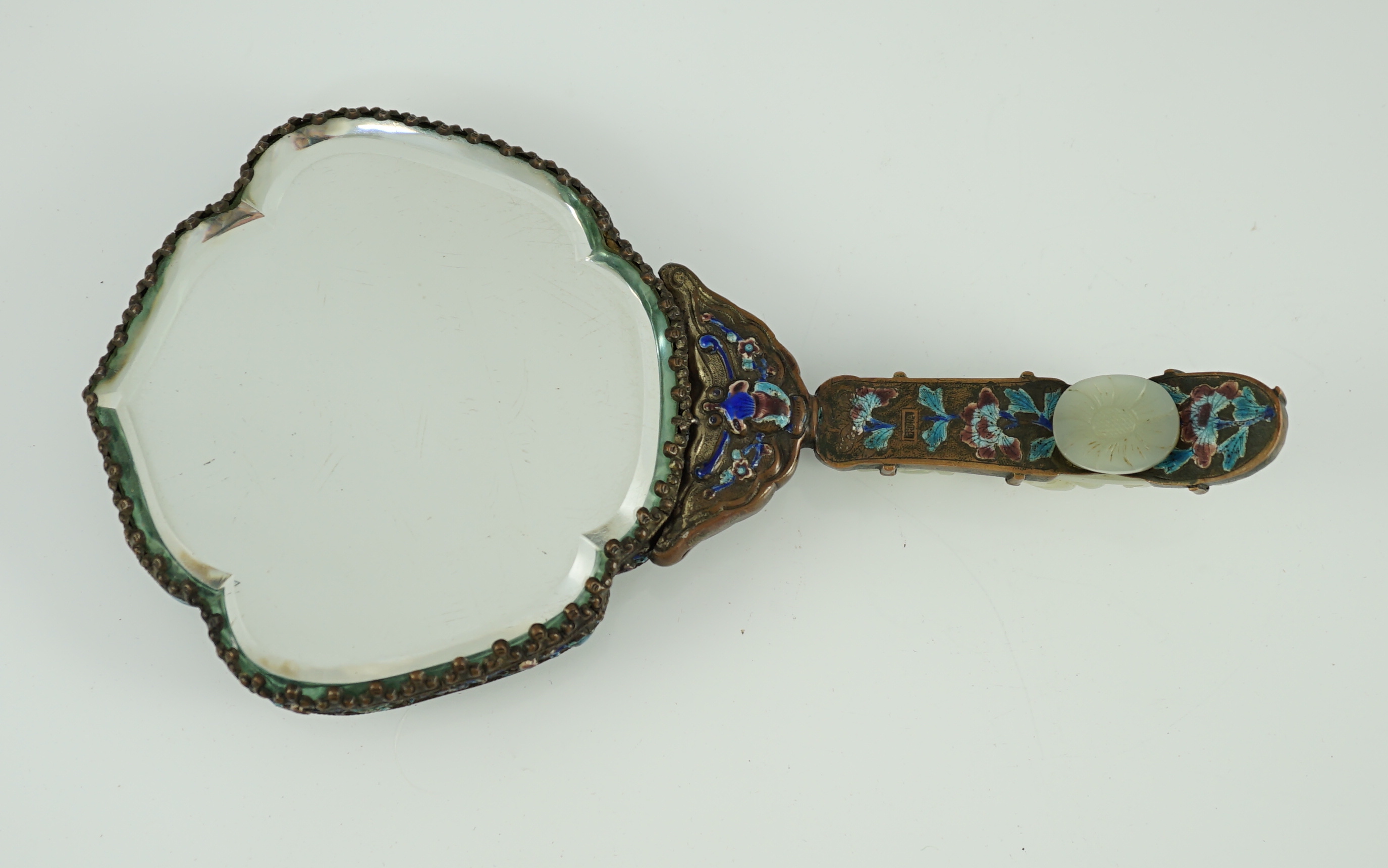 An early 20th century Chinese enamelled copper hand mirror with 18th/19th century Chinese pale celadon jade mounts